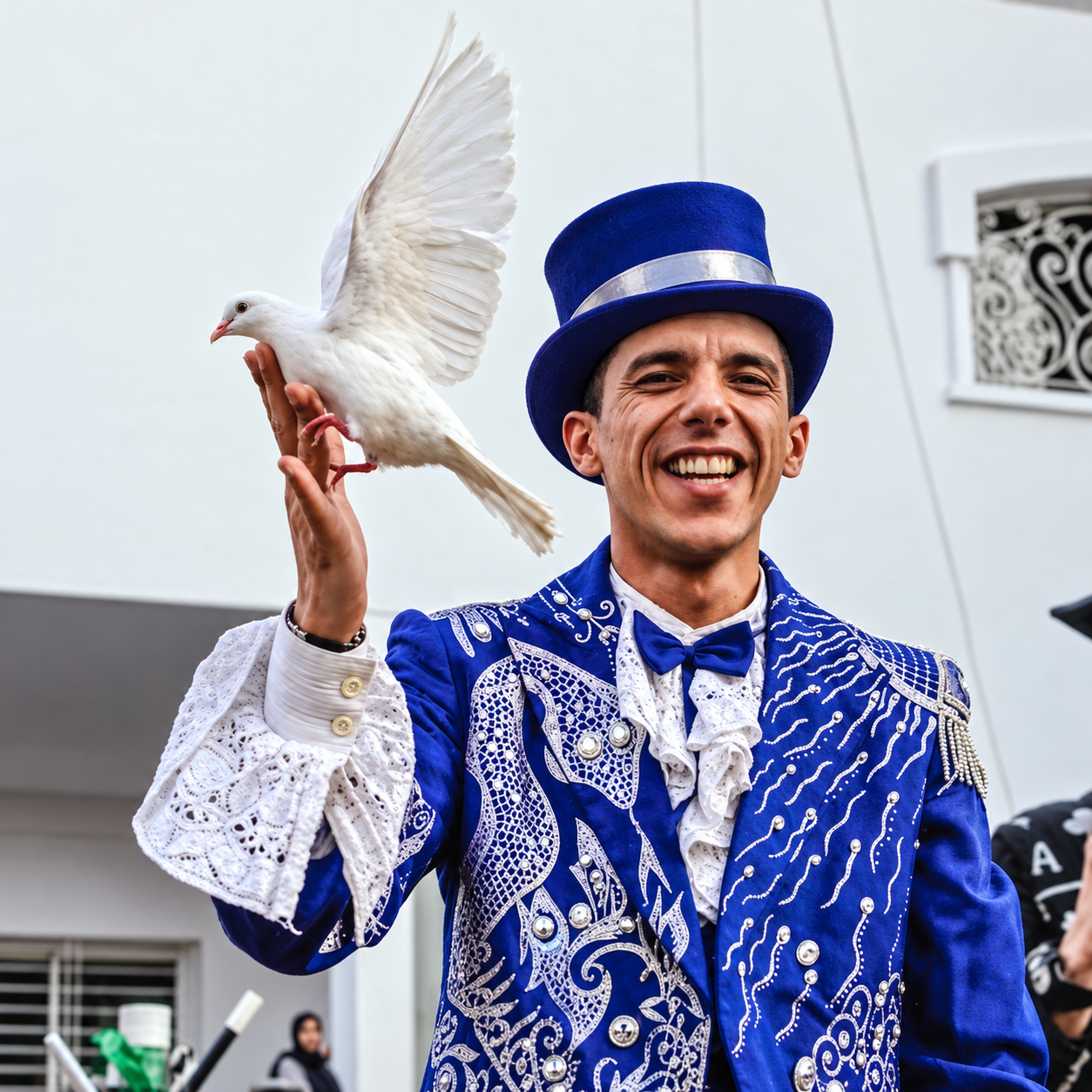 Magicien en costume bleu avec une colombe blanche